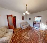 Rodinný dom v obci Bojná - Obývačka rodinného domu s farebným kobercom, pohovkami a drevenou obývacou stenou.