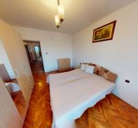 Rodinný dom v obci Bojná - Spálňa s posteľou, skriňou a podlahou s dreveným dekorom v rodinnom dome.