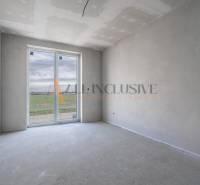 ALL INCLUSIVE I 3 IZBOVÉ BYTY S TERASOU, SO ZÁHRADOU + 2 PARK. MIESTA - Priestranná miestnosť s oknom v 3-izbovom byte so surovou podlahou.