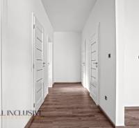 ALL INCLUSIVE I 3 IZBOVÉ BYTY S TERASOU, SO ZÁHRADOU + 2 PARK. MIESTA - Chodba v 3-izbovom byte s bielymi dverami a podlahou s dreveným dekorom.