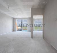 ALL INCLUSIVE I 3 IZBOVÉ BYTY S TERASOU, SO ZÁHRADOU + 2 PARK. MIESTA - Nedokončený interiér 3-izbového bytu s omietnutými stenami a veľkými oknami.