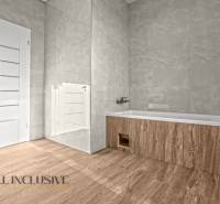 ALL INCLUSIVE I 3 IZBOVÉ BYTY S TERASOU, SO ZÁHRADOU + 2 PARK. MIESTA - Kúpeľňa v 3-izbovom byte s podlahou s dreveným dekorom, vaňou a bielymi dverami.