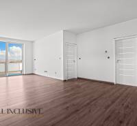 ALL INCLUSIVE I 3 IZBOVÉ BYTY S TERASOU, SO ZÁHRADOU + 2 PARK. MIESTA - Priestranný interiér 3-izbového bytu s podlahou s dreveným dekorom a výhľadom z okna.