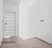 ALL INCLUSIVE I 3 IZBOVÉ BYTY S TERASOU, SO ZÁHRADOU + 2 PARK. MIESTA - Vstupná chodba v 3-izbovom byte s dlažbou a bielymi dverami.