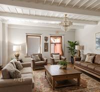 Vidiecky dom v Zemplínskej Teplici - Obývačka v rodinnom dome s koženou sedačkou, podlahou s dreveným dekorom a kobercom.