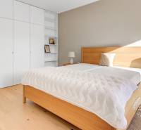 NOVÝ krásny 2i byt, ZWIRN, 2x balkón, parkovanie, Košická - Spálňa s podlahou s dreveným dekorom, bielymi skriňami a drevenou posteľou v 2-izbovom byte.
