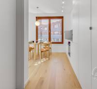 NOVÝ krásny 2i byt, ZWIRN, 2x balkón, parkovanie, Košická - Svetlá jedáleň s podlahou s dreveným dekorom v 2-izbovom byte so stolom a stoličkami.