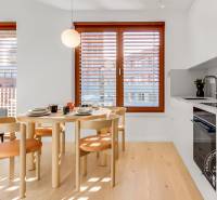 NOVÝ krásny 2i byt, ZWIRN, 2x balkón, parkovanie, Košická - Jedálenský kút v 2-izbovom byte s drevenými stoličkami a podlahou s dreveným dekorom.