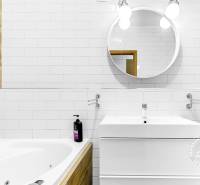 Krásny 3i byt, LODŽIA, PARKING, Dúbravka, Cabanova - Kúpeľňa v 3-izbovom byte s vaňou, bielym obkladom a dreveným dekorom na stenách.