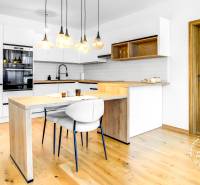 Krásny 3i byt, LODŽIA, PARKING, Dúbravka, Cabanova - Kuchyňa v 3-izbovom byte s bielymi skrinkami a podlahou s dreveným dekorom.