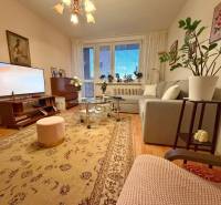 - PREDAJ - 3 izbový byt - Estónska ul. - Vrakuňa  - Obývačka v 3-izbovom byte s príjemným osvetlením, podlahou s dreveným dekorom a pohodlnou sedačkou.