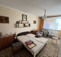 Šahy – 3i Byt v Centre Mesta s Balkónom  - Izba v 3-izbovom byte s postieľkou, kobercom a nábytkom, dekorácie na stenách.