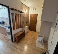 Šahy – 3i Byt v Centre Mesta s Balkónom  - Interiér 3-izbového bytu s podlahou s dreveným dekorom a vešiakom na stene.