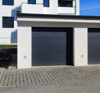 | 2-izbový byt, ul. Predmerského VINOHRADY | Trenčín  - Garáže na ulici Predmerského v Trenčíne s bytovým domom v pozadí.