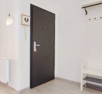 | 2-izbový byt, ul. Predmerského VINOHRADY | Trenčín  - Vstupná chodba so svetlými stenami a podlahou s dreveným dekorom, vedie do spálne.