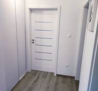 PREDAJ - 3-izbový veľkometrážny byt v RED OAK, Lužianky - REZERVOVANÉ - Chodba v 3-izbovom byte s bielymi dverami a podlahou s dreveným dekorom.
