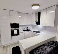 PREDAJ - 3-izbový veľkometrážny byt v RED OAK, Lužianky - REZERVOVANÉ - Kuchyňa s bielymi skrinkami a podlahou s dreveným dekorom v 3-izbovom byte.