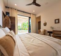 LUXURY 2-BEDROOM VILLA IN PAJE - Interiér spálne s priestrannou posteľou a výhľadom na terasu, Výstavba domov.