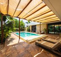 LUXURY 2-BEDROOM VILLA IN PAJE - Záhrada rodinného domu na ulici Paje v Unguja South Region s bazénom a lehátkami.