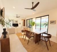 LUXURY 2-BEDROOM VILLA IN PAJE - Interiér s jedálenským stolom, podlahou s dreveným dekorom a veľkými sklenenými dverami, Výstavba domov.