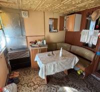 Apartim predá záhradu s možnosťou výstavby na Strednej ul v Ružinove - Interiér chaty so starožitným vzorovaným stolom a drevenými detailami v Záhradách.