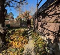 Apartim predá záhradu s možnosťou výstavby na Strednej ul v Ružinove - Úzka záhrada v Bratislave - Ružinove na Strednej ulici s chodníkom a stromami.