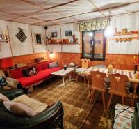 Útulná chata polosamota Tále Nízke Tatry - Útulný interiér chaty s dekorovaným stolom, sedačkou a drevenými stoličkami.