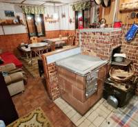 Útulná chata polosamota Tále Nízke Tatry - Interiér chaty s tradičným tehlovým sporákom, podlahou s dreveným dekorom a pohodlným posezením.