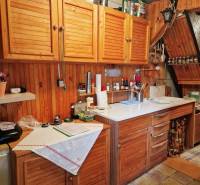 Útulná chata polosamota Tále Nízke Tatry - Kuchyňa v chate s drevenými skrinkami a bielym pracovným pultom, útulná atmosféra.