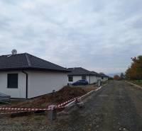 Na predaj rodinný dom, novostavba, bungalov, Vyšná Šebastová, Prešov - Rodinný dom na Vyšnej Šebastovej v Prešove, stavba so štrkovou cestou a stromami.