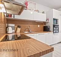 NA PREDAJ 3-IZB. BYT S TERASOU A ZÁHRADKOU, DUN.STREDA - Kuchyňa v 3-izbovom byte s bielymi skrinkami a podlahou s dreveným dekorom.