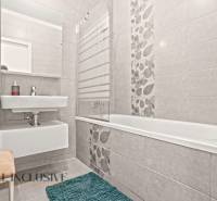 NA PREDAJ 3-IZB. BYT S TERASOU A ZÁHRADKOU, DUN.STREDA - Kúpeľňa v 3-izbovom byte so sprchovou vaňou, umývadlom a dekoratívnymi dlaždicami na stenách.