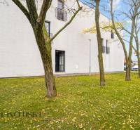 NA PREDAJ 3-IZB. BYT S TERASOU A ZÁHRADKOU, DUN.STREDA - Exteriér 3-izbového bytu v Dunajskej Strede s trávnikom a stromami počas jesene.