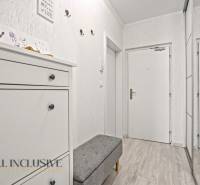 NA PREDAJ 3-IZB. BYT S TERASOU A ZÁHRADKOU, DUN.STREDA - Chodba v 3-izbovom byte s bielym nábytkom a podlahou s dreveným dekorom.