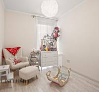 NA PREDAJ 3-IZB. BYT S TERASOU A ZÁHRADKOU, DUN.STREDA - Detská izba v 3-izbovom byte s pohodlným kreslom a hračkami, podlaha s dreveným dekorom.