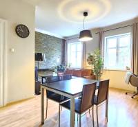 PRIESTRANNÝ 2.IZB. BYT - PIVNICA, LODŽIA - DOBROVSKÉHO, STARÉ MESTO - Jedálenský stôl v obývačke 2-izbového bytu s podlahou s dreveným dekorom.