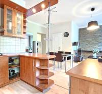 PRIESTRANNÝ 2.IZB. BYT - PIVNICA, LODŽIA - DOBROVSKÉHO, STARÉ MESTO - Kuchyňa v 2-izbovom byte s podlahou s dreveným dekorom a svetlým nábytkom.