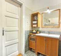 PRIESTRANNÝ 2.IZB. BYT - PIVNICA, LODŽIA - DOBROVSKÉHO, STARÉ MESTO - Kúpeľňa v 2-izbovom byte s dreveným dekorom nábytku a keramickými obkladmi.