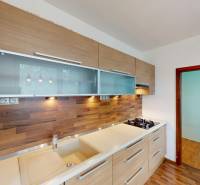 3-izbový byt prerobený na 4-izbový – Ku Bratke, Levice  - Kuchyňa v 3-izbovom byte má podlahu s dreveným dekorom a zabudované spotrebiče.