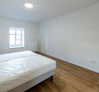 Moderný, priestranný 2i byt 70m2, v tichom dvore, úplne nový - Spálňa s posteľou a podlahou s dreveným dekorom v 2-izbovom byte.