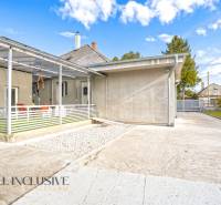 NA PREDAJ 4+1-IZBOVÝ ROD. DOM, VEĽKÉ KOSIHY - Rodinný dom vo Veľkých Kosihách: betónová terasa, prístrešok, záhrada, modrá obloha.