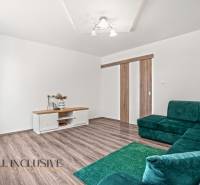 NA PREDAJ 4+1-IZBOVÝ ROD. DOM, VEĽKÉ KOSIHY - Interiér rodinného domu s podlahou s dreveným dekorom, zelenou sedačkou a stolíkom.