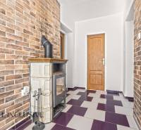 NA PREDAJ 4+1-IZBOVÝ ROD. DOM, VEĽKÉ KOSIHY - Interiér rodinného domu s kachľovou pecou a tehlovými stenami.