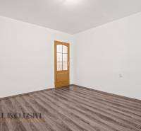 NA PREDAJ 4+1-IZBOVÝ ROD. DOM, VEĽKÉ KOSIHY - Biely interiér s dverami a podlahou s dreveným dekorom v rodinnom dome.