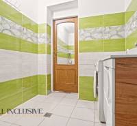 NA PREDAJ 4+1-IZBOVÝ ROD. DOM, VEĽKÉ KOSIHY - Kúpeľňa v rodinnom dome s farebnými obkladmi, drevenými dverami a práčkou.
