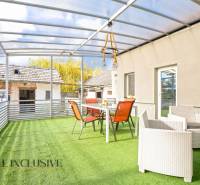 NA PREDAJ 4+1-IZBOVÝ ROD. DOM, VEĽKÉ KOSIHY - Terasa rodinného domu vo Veľkých Kosihách s presklenou strechou a nábytkom na umelej tráve.