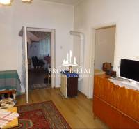 Rodinný dom, chalupa 2 Izbový - Fony - Obývacia izba v rodinnom dome s kobercom a podlahou s dreveným dekorom.