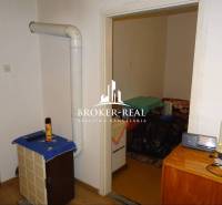 Rodinný dom, chalupa 2 Izbový - Fony - Interiér rodinného domu s vykurovacím telesom, nábytkom a podlahou s dreveným dekorom.