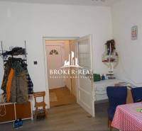 Rodinný dom, chalupa 2 Izbový - Fony - Interiér rodinného domu s podlahou s dreveným dekorom, jedálenským stolom a vešiakom na oblečenie.