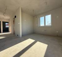 PREDAJ - NOVOSTAVBA - TESÁRSKE MLYŇANY - Interiér rodinného domu s nedokončenými stenami a oknom, podlaha s dreveným dekorom.